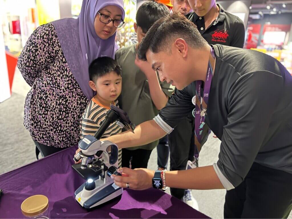 A group of people are looking at a microscope.