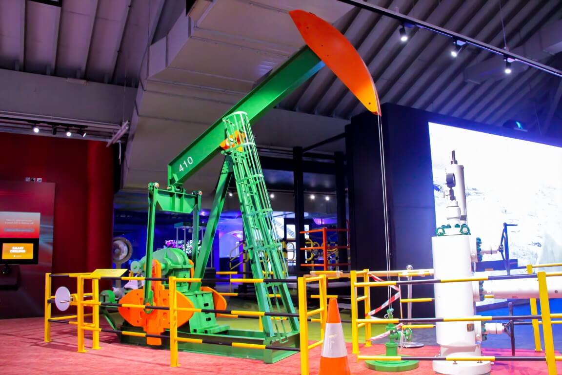 A colorful oil pumpjack model on display.