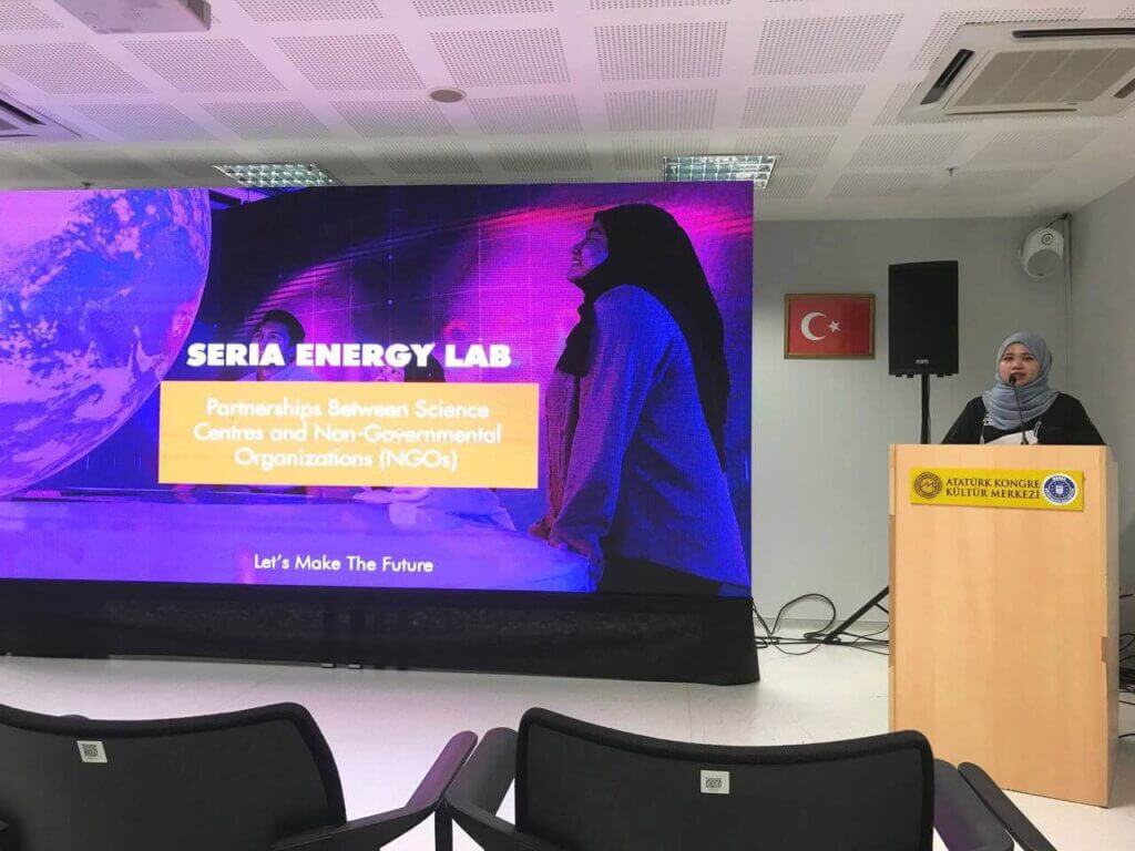 A woman presents at ASPAC Fellowship Grant 2022 in Bursa, Turkey, by a screen displaying "Seria Energy Lab."